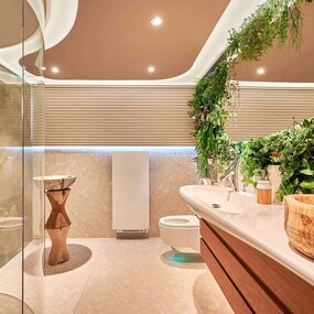 Modernes Badezimmer mit Naturdeko, Pflanzenwand, Holzwaschbecken und eleganter Beleuchtung.