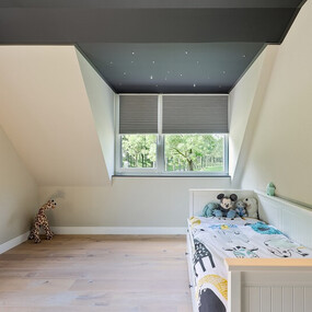 Modernes Kinderzimmer mit Dachschräge, Holzboden, Fenster und gemütlichem Bett.
